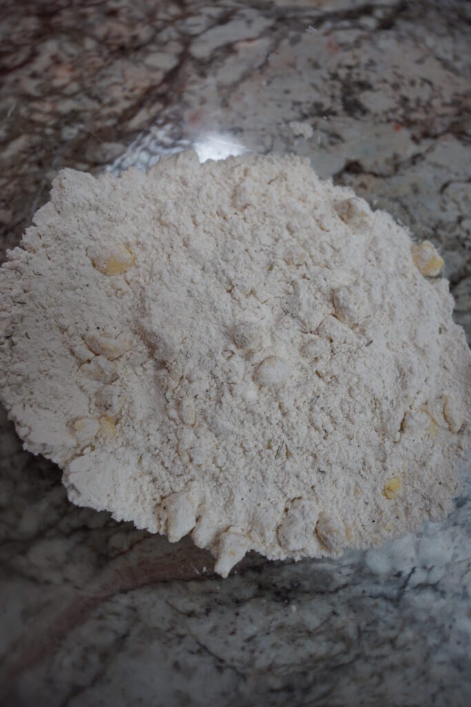 Whisked dry ingredients for autumn seasoned biscuits with cold butter cut into small cubes throughout.