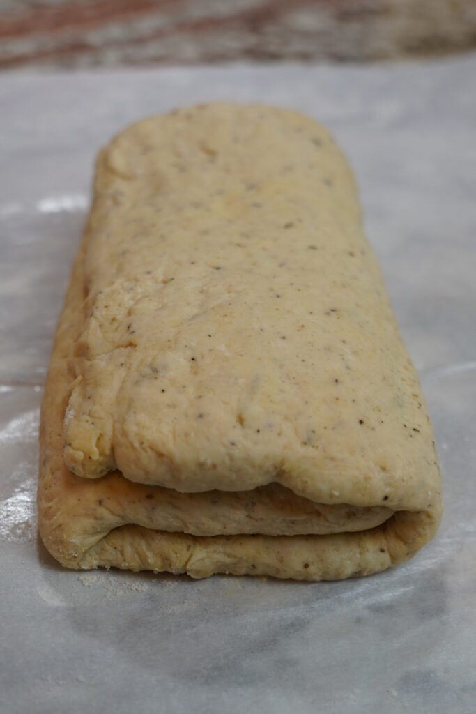 autumn seasoned biscuit dough rolled out and folded over like a pamphlet, so that it's in 3 layers.