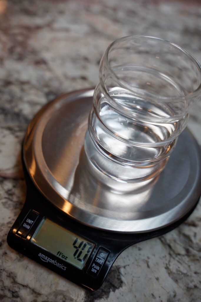 2 ounces of water added to glass cup of scale.