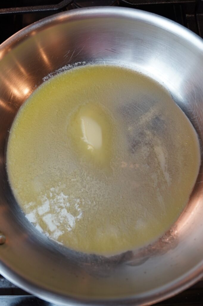 Butter melting in a pan for brown sugar dijon glazed ham steak