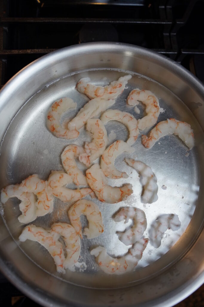 Cajun Shrimp Pasta Step 1. Shrimp boiling in a large all clad stainless steel pan.
