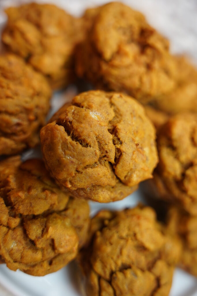 Pumpkin Banana Nut Muffins Completed, Stacked on a white plate, close up.
