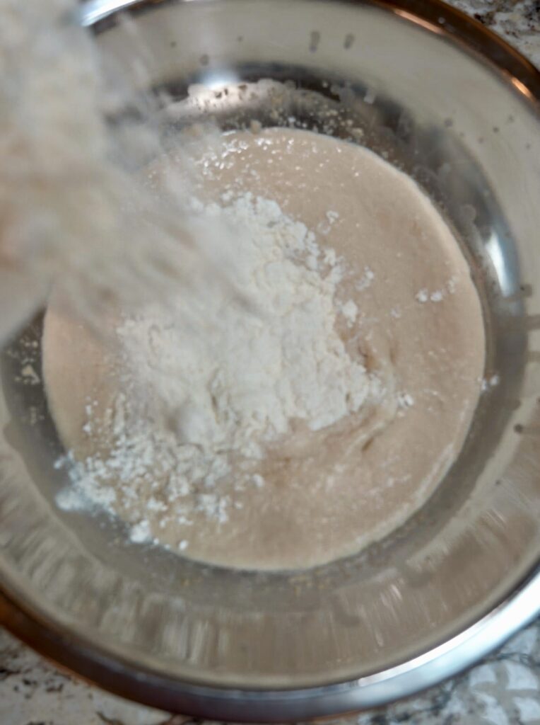 Step 2 making pumpkin shaped dinner rolls - adding the flour mix to the activated yeast.