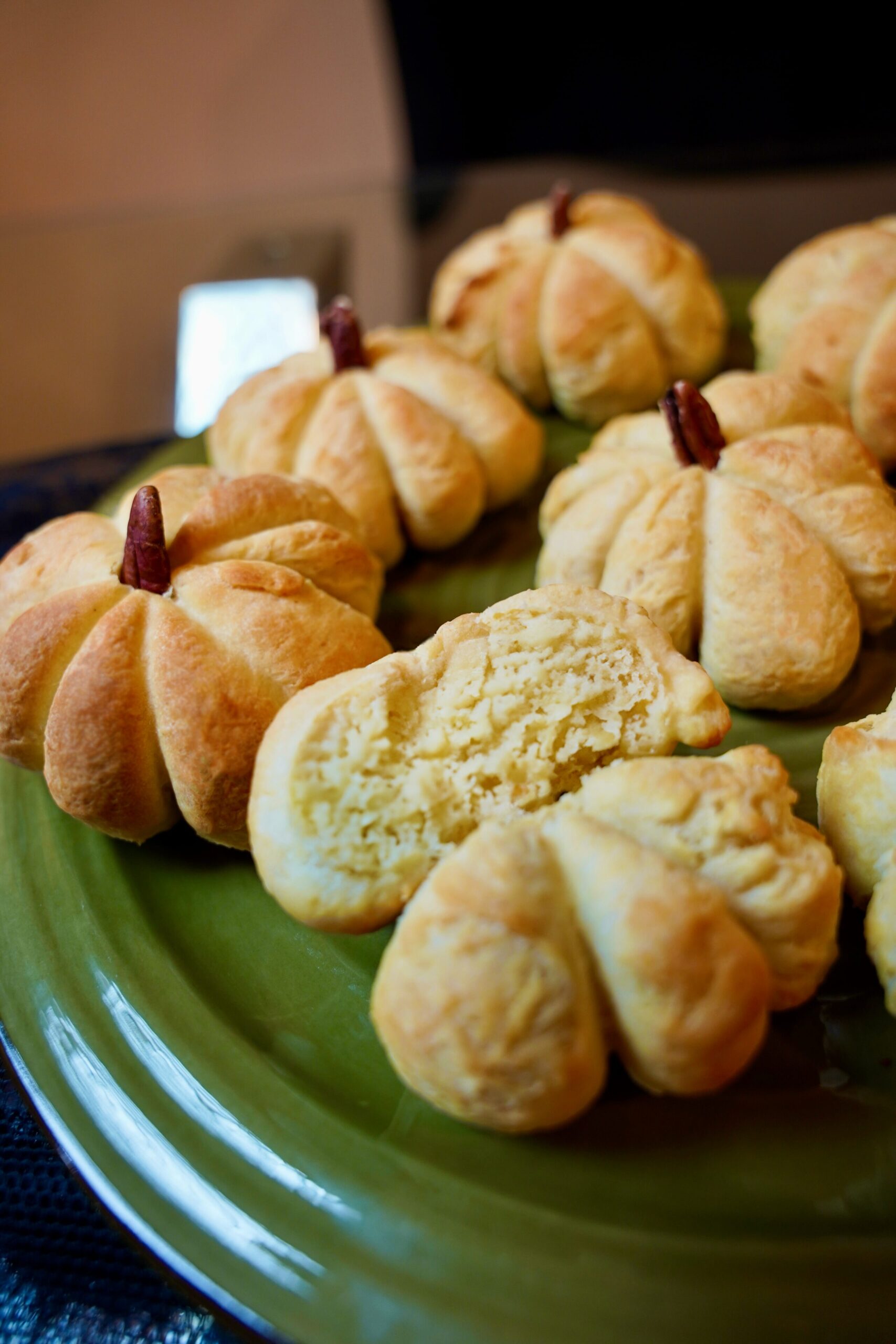 Pumpkin Shaped Dinner Rolls with a pecan halved as a stem. Torn in half to show the delicious texture.