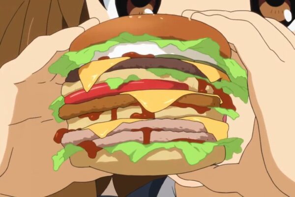 Large multilayer burger with several meat patties and pieces of cheese. Being held by a girl with brown eyes who's looking at it with wonder.